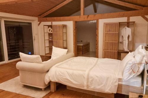 a bedroom with a white bed and a couch at Charming 6 bed chalet in 4 Valleés in Iserables