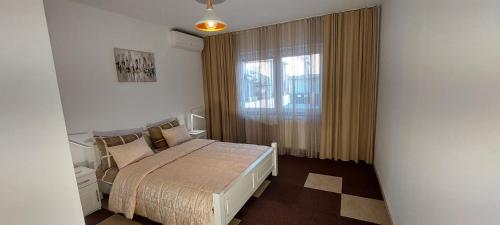 a small bedroom with a bed and a window at MB apartmani Sarajevo in Sarajevo