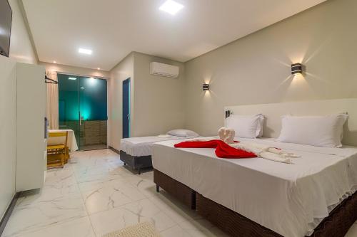 ein Schlafzimmer mit 2 Betten und einer Puppe auf dem Bett in der Unterkunft Hotel Pousada Tribalista in Arraial d'Ajuda