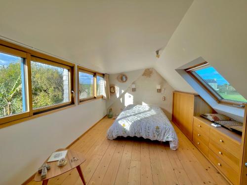 une chambre avec un lit dans une pièce avec des fenêtres dans l'établissement Ty Goas, à Kerlouan