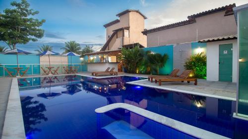 eine Villa mit einem Pool vor einem Haus in der Unterkunft Hotel Pousada Tribalista in Arraial d'Ajuda