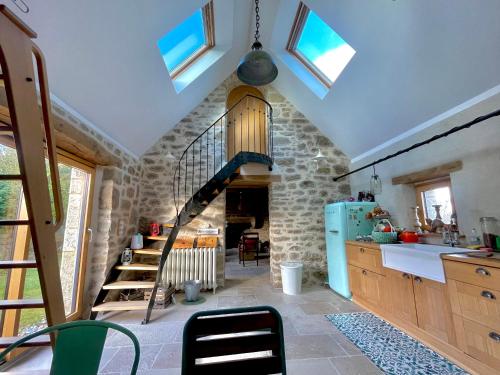 une cuisine avec un escalier en colimaçon dans une pièce dans l'établissement Ty Goas, à Kerlouan