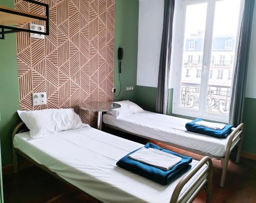 2 łóżka w małym pokoju z oknem w obiekcie Oops! Latin quarter by Hiphophostels w Paryżu