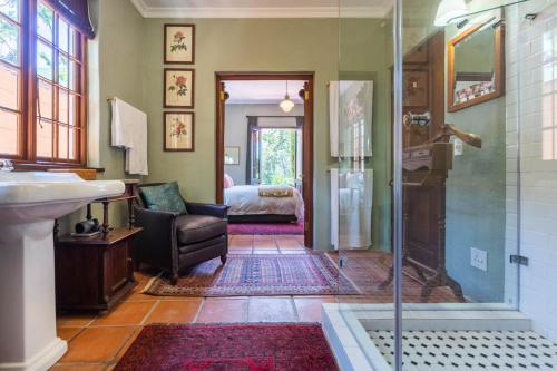 1 dormitorio y baño con ducha y lavabo. en Kensington Views en Ciudad del Cabo