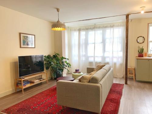 ein Wohnzimmer mit einem Sofa und einem Flachbild-TV in der Unterkunft Charming flat in historic centre by Santa Maria in Bermeo