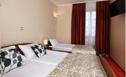 1 dormitorio con 2 camas y una ventana con cortinas rojas en Guesthouse Risnik, en Divača