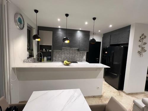 a kitchen with a white counter and a black refrigerator at Lou et Hans in Aalst