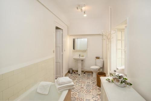 La salle de bains blanche est pourvue d'une baignoire et d'un lavabo. dans l'établissement Château pour se retrouver, à Larochemillay