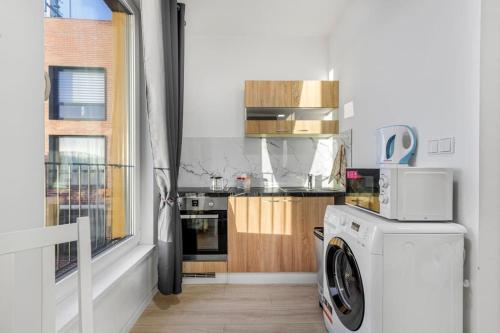 uma cozinha com uma máquina de lavar roupa e uma janela em Apartment in Prague N1 em Praga