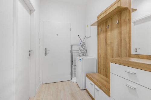uma cozinha com armários brancos e um frigorífico em Apartment in Prague N1 em Praga