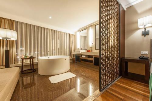 un ampio bagno con vasca e lavandino di SSAW Boutique Hotel Hefei Intime Centre a Hefei