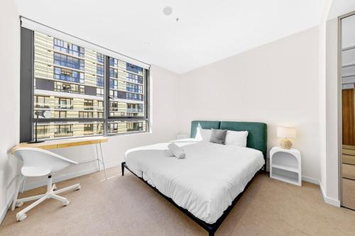 a bedroom with a bed and a desk and a window at Executive Two-Bedroom Apartment in Macquarie Park in Sydney