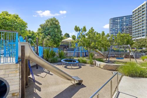 a playground with a slide in a park at Executive Two-Bedroom Apartment in Macquarie Park in Sydney