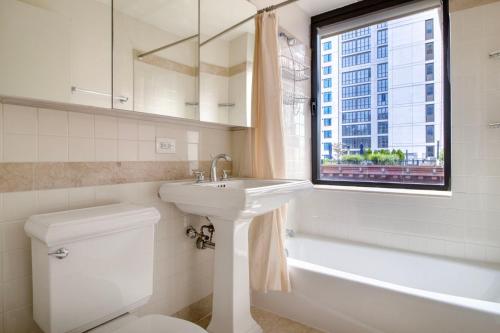 a bathroom with a sink and a toilet and a window at Upper West Side 1br w doorman nr park NYC-1219 in New York