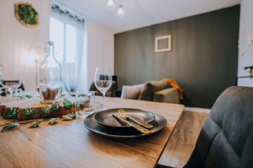 a dining room table with a plate and wine glasses at Le Bertrand • Le Raffinement en Cœur de Ville in Châteauroux