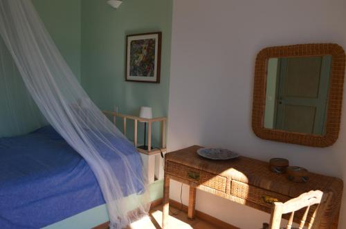 a bedroom with a bed and a mirror and a table at Sea Breeze Bliss in Lixouri