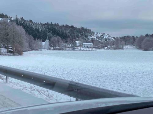 a view of a snow covered lake from a car at Klostergården 