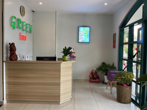 sklep z zielonym znakiem na ścianie w obiekcie Green Inn Phu Quoc Hotel w Duong Dong