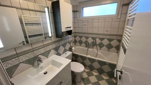 a bathroom with a sink and a toilet and a mirror at Apartment in Laatzen! contactless check-in in Hannover