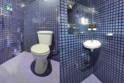 Baño de azulejos azules con aseo y lavamanos en Comfort Holiday Home en Baga