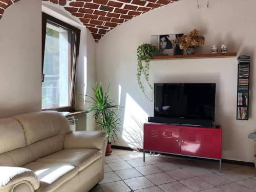 a living room with a couch and a flat screen tv at Ca' Cuore in Monferrato in Serralunga di Crea