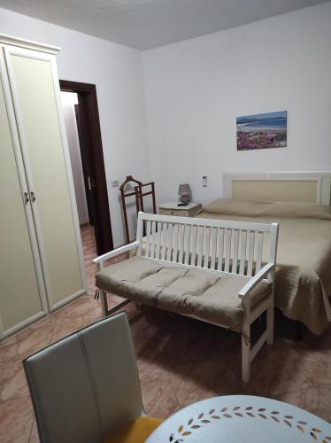 錫尼斯科拉的住宿－MONOLOCALE YELLOW，一间卧室配有一张床、一张长凳和一张桌子