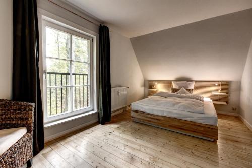 a bedroom with a bed and a large window at Gut Thansen Forsthaus in Soderstorf