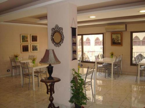 una sala da pranzo con tavoli, sedie e specchio di Rafi Hotel ad Amman