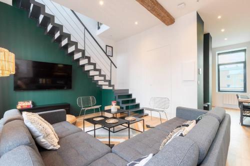- un salon avec un canapé et un escalier dans l'établissement Spacious house 11 bedrooms 8 bathrooms 22 people., à Roubaix