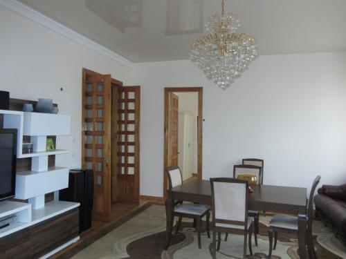 a dining room with a table and chairs and a chandelier at Fortuna 2024 in Kutaisi