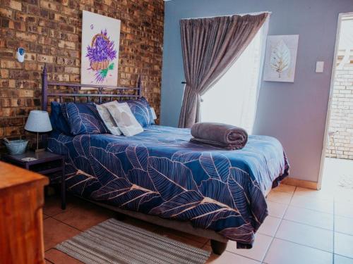 a bedroom with a bed and a brick wall at Stay at 12 Guesthouse and Selfcatering in Middelburg