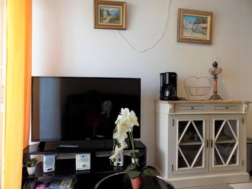 Il comprend un salon doté d'une télévision à écran plat et d'une armoire. dans l'établissement Royan - APPARTEMENT au COEUR du CENTRE-VILLE - PLAGE à SEULEMENT 200m, à Royan