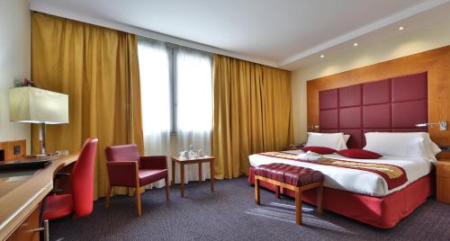 a hotel room with a large bed and a desk at Crowne Plaza Venice East by IHG in Quarto dʼAltino
