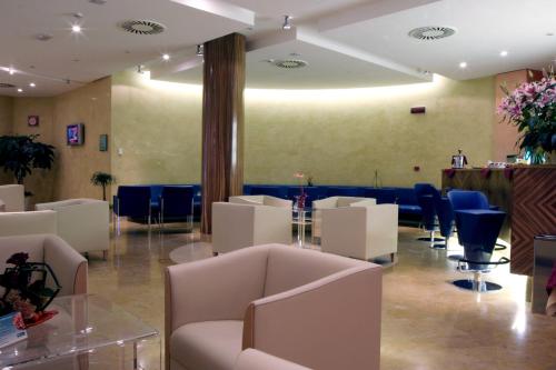 a waiting room with white furniture and blue chairs at Crowne Plaza Venice East by IHG in Quarto dʼAltino