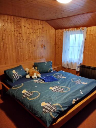 a teddy bear laying on a bed in a room at Prázova Bouda in Dobré