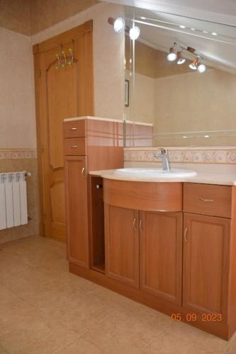 a bathroom with a sink and a large mirror at Cómoda casa en Cabárceno in Villanueva