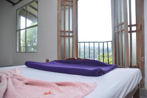 a bed with a purple blanket on top of it at Mountain View in Bandarawela