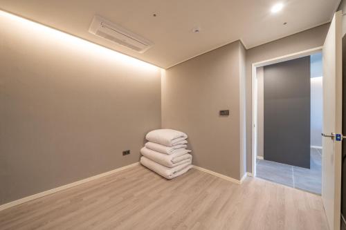 a living room with a white chair in a room at Le Bleu Naksan by Chestertons in Yangyang