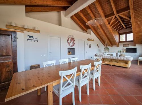a dining room with a wooden table and white chairs at COUNTRY HOUSE LA MIA TERRA in Angera