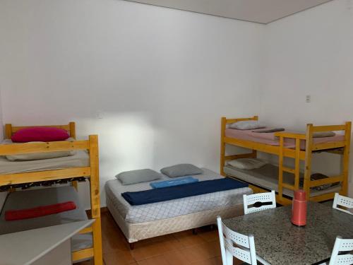 a room with three bunk beds and a table at 105 Apartamento exclusivo Wi-Fi in Brasilia
