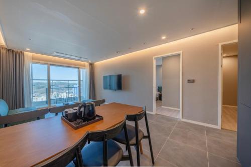 a dining room with a table and chairs and a room at Chestertons Naksan in Yangyang