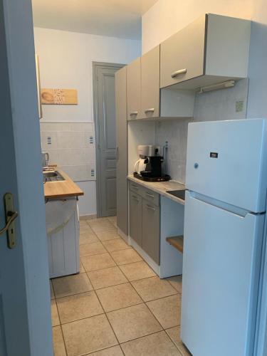 Il comprend une cuisine équipée d'un réfrigérateur blanc. dans l'établissement L'Ermitage, à Pornic