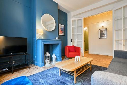 Elle comprend un salon doté de murs bleus et d'une cheminée. dans l'établissement 3 bedroom apartment, close to all amenities, à Lille