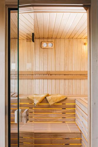 a sauna with wooden walls and a glass door at LIPA houses & spa in Sopot