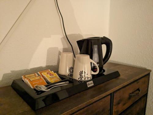 a coffee maker and cups on top of a dresser at Gasthaus "Zum Goldenen Roß" in Uhlstädt