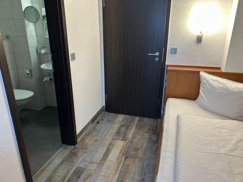 a bedroom with a bed and a bathroom with a toilet at Hotel Fackelmann in Nürnberg