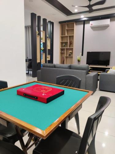 a ping pong table in a room with a couch at 16 Paxs Bungalow Homestay Hutan Melintang by Aloha in Hutan Melintang