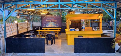 ein Restaurant mit Tischen und Stühlen in einem Gebäude in der Unterkunft Knight Residence in Pantai Cenang