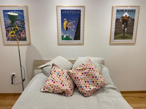 two pillows on a bed with two posters on the wall at Eckhuetteins in Bernried