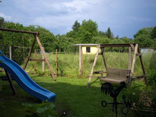 un parque infantil con un columpio y un tobogán en Ferienwohnung direkt an der Nied, 